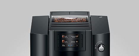 Vista frontal de la cafetera E6 Piano Black donde se aprecia la pantalla y el depósito de café en grano